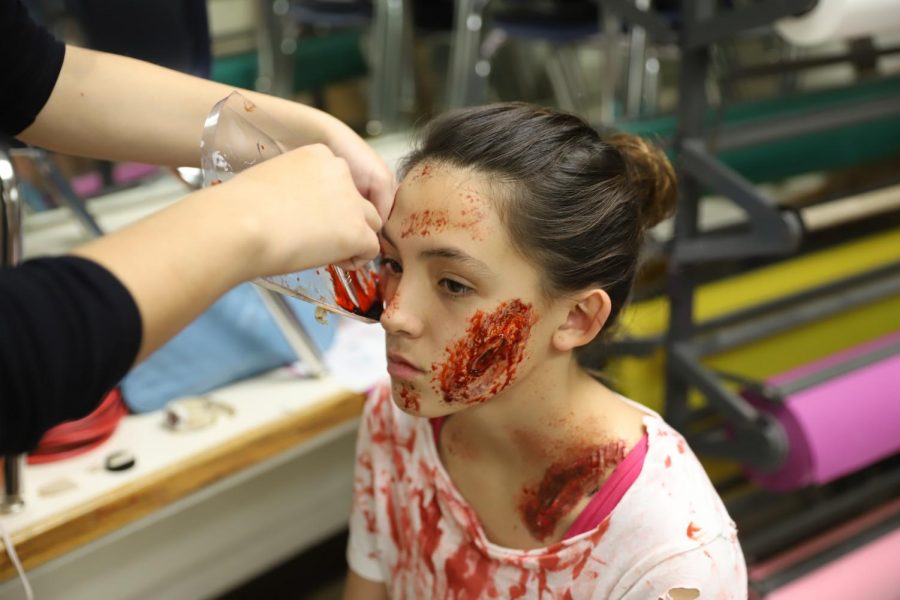 Freshman, Allyson Stresow, getting effects makeup in preparation of the haunted house event.